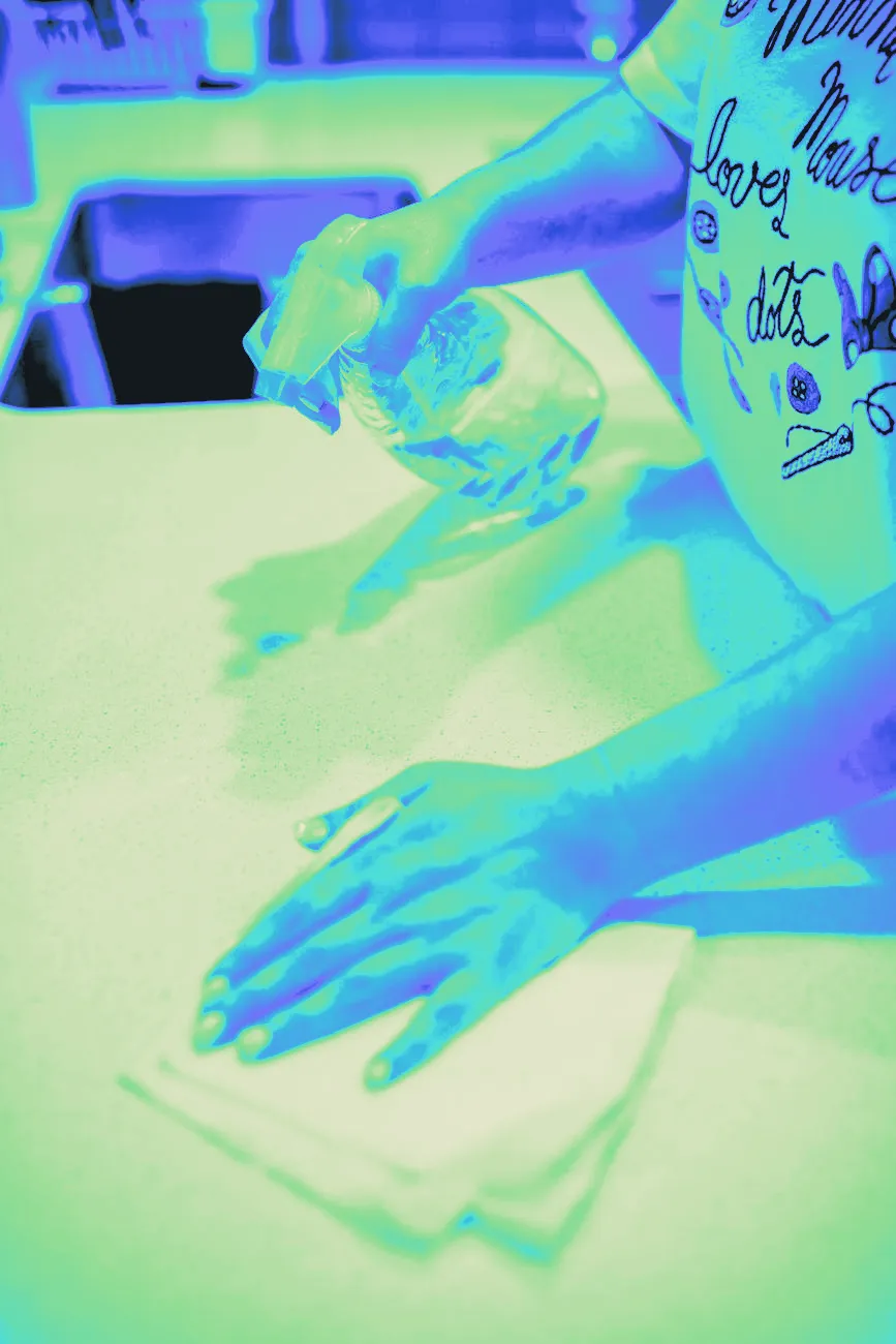 A cloth wiping a counter surface, captured mid-motion