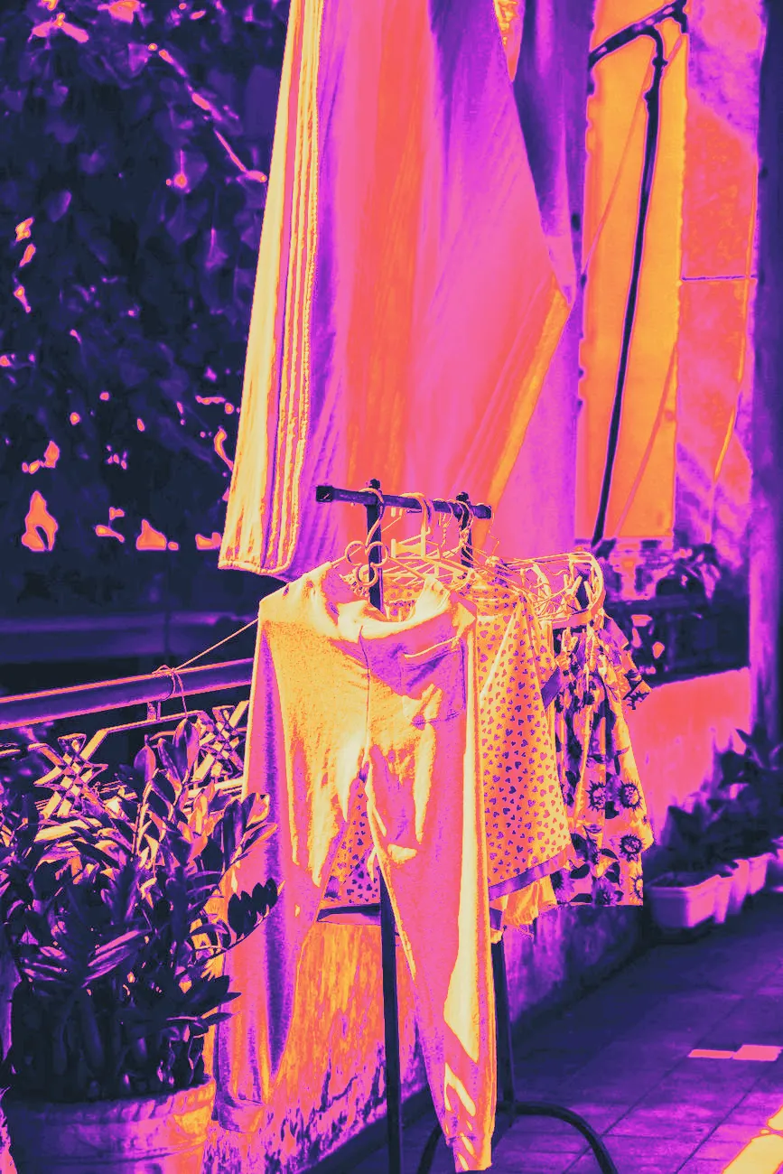 Small baby clothes hanging to dry on a rack in soft sunlight