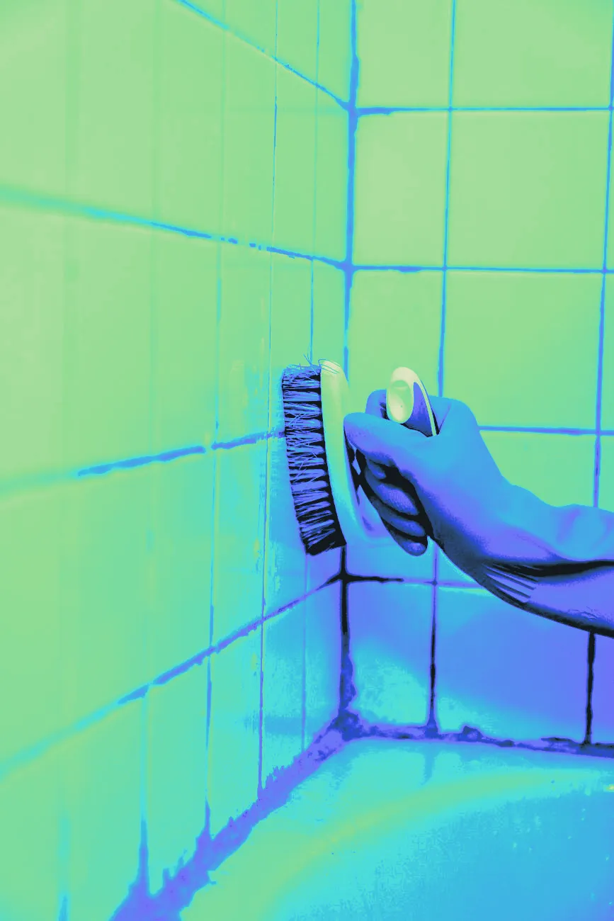 A brush scrubbing bathroom tile, shown close up