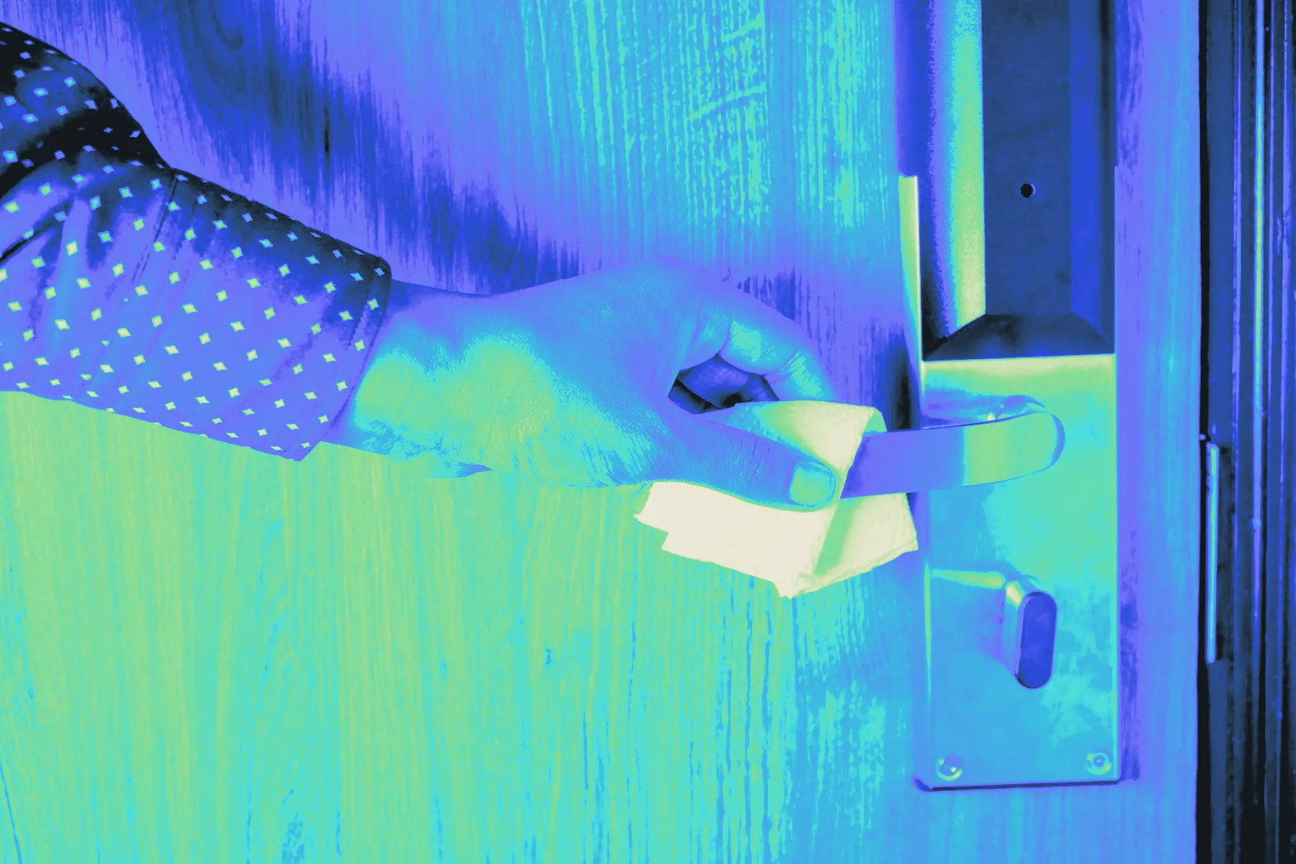 A wipe cleaning a doorknob, captured close up