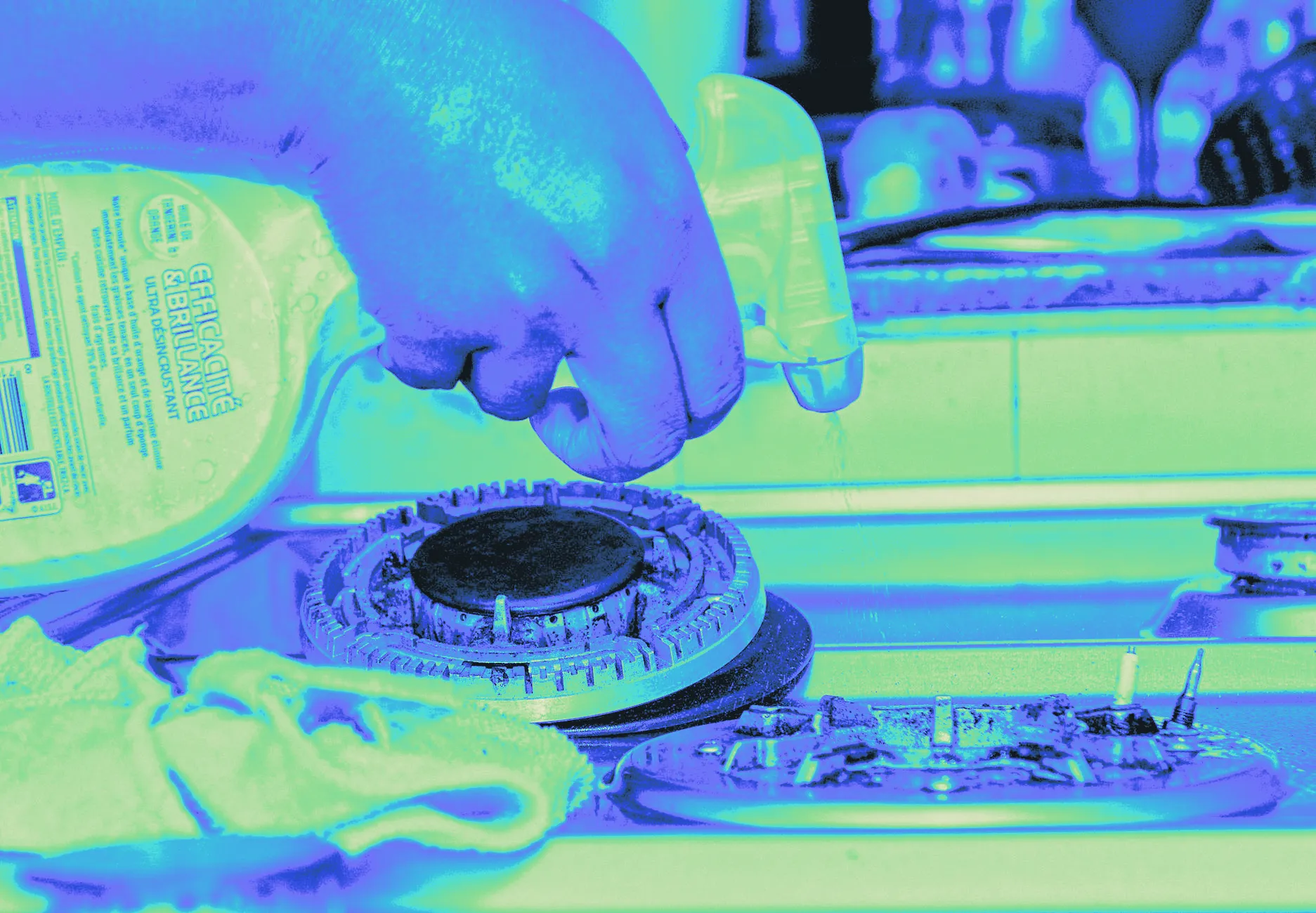 A stovetop being scrubbed clean, shown close up