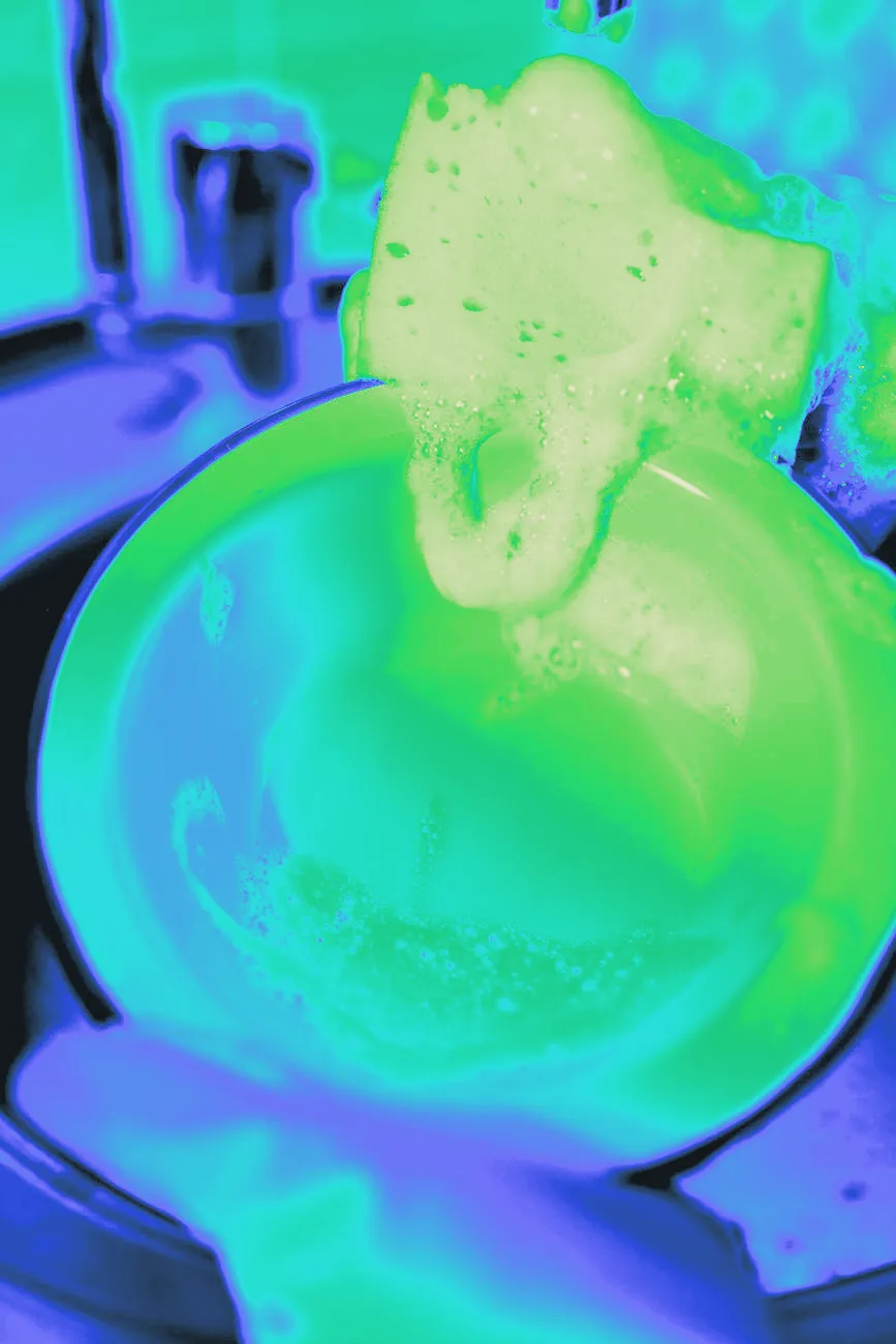 Yellow gloved hands washing dishes in a sink