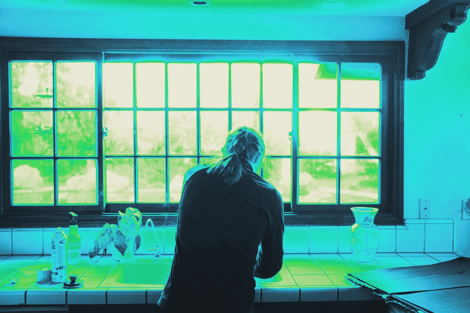 A glass of water catching sunlight on a kitchen counter