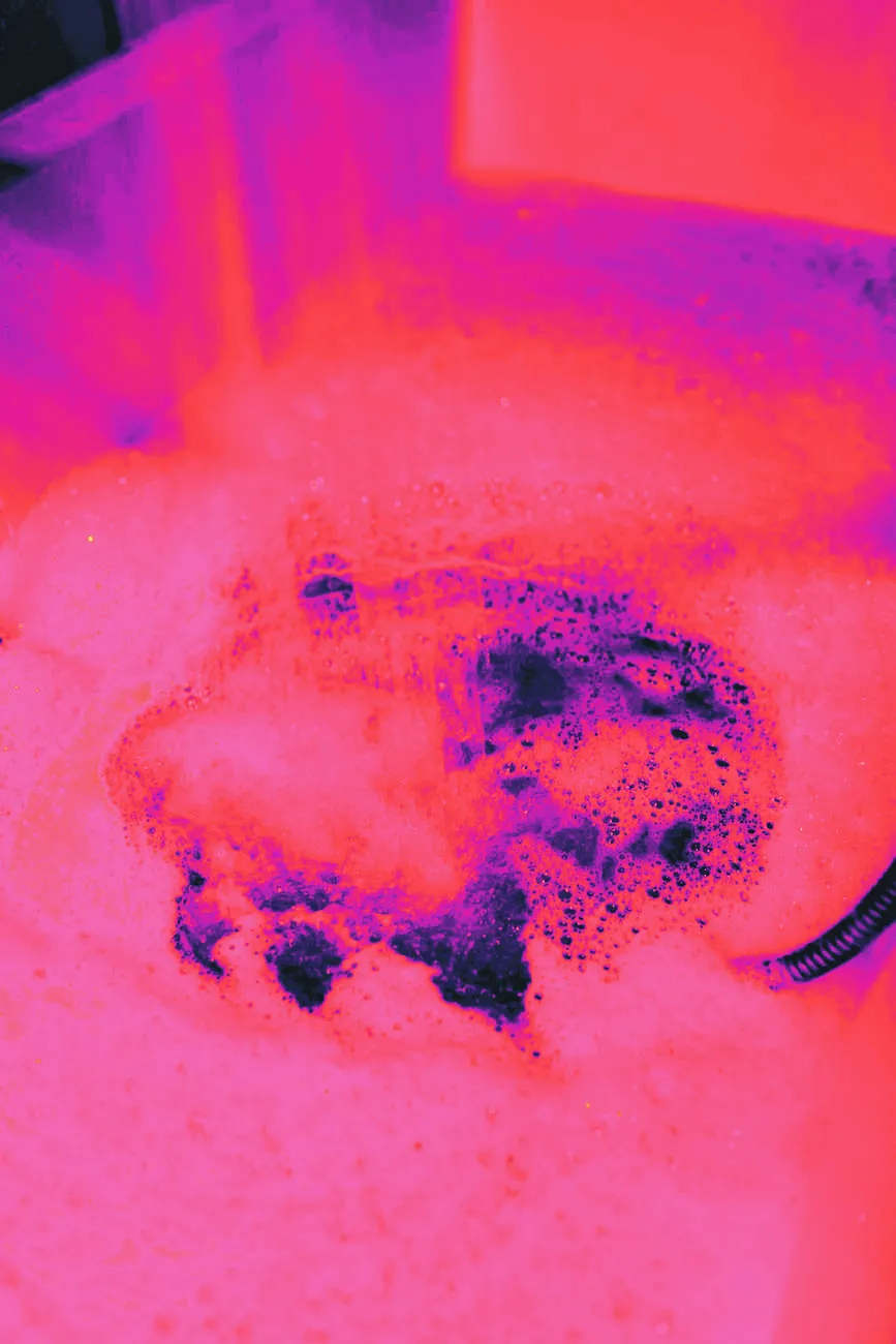 A dog in a bathtub with water and suds