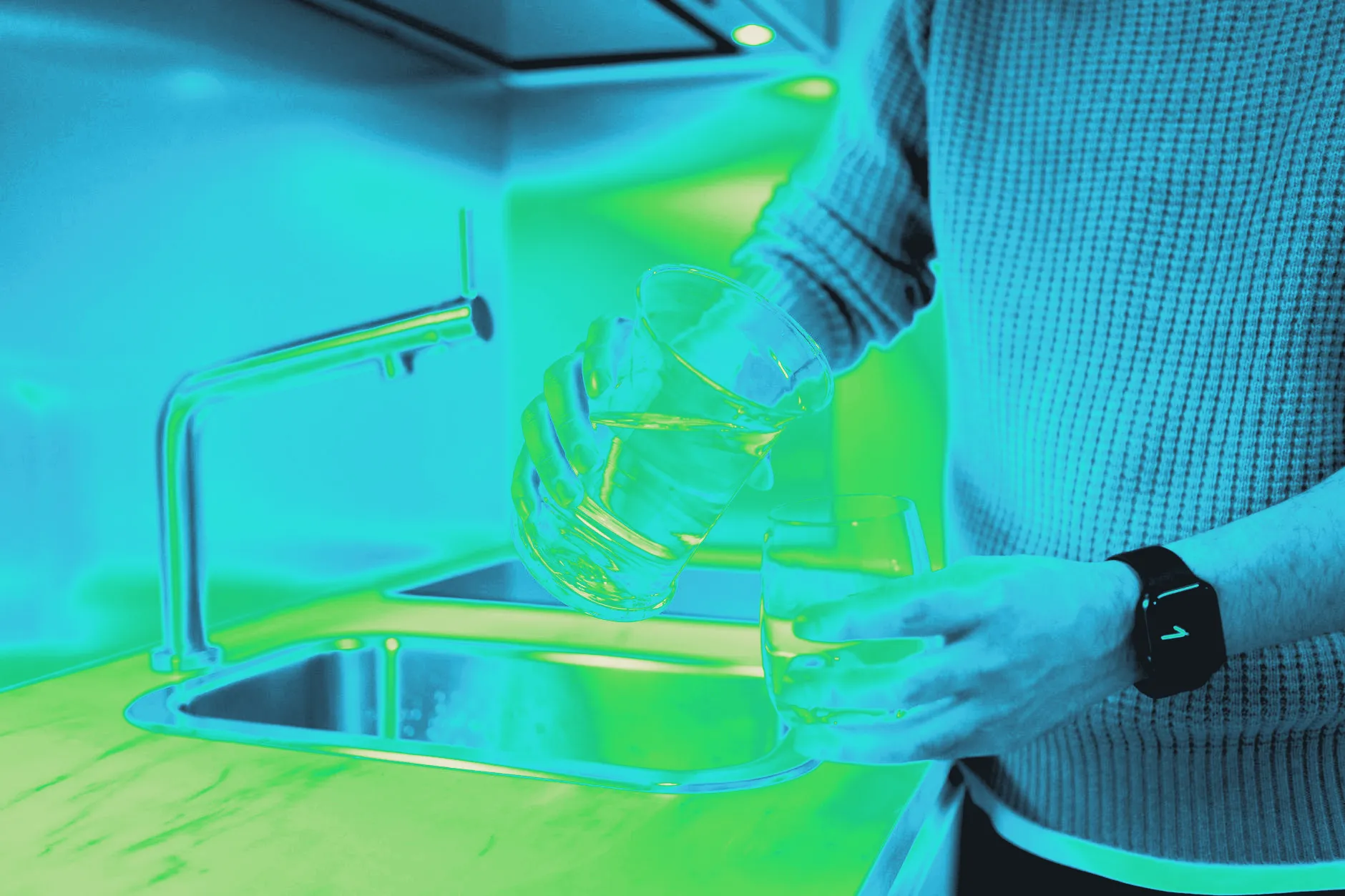 Water being poured into a glass in a kitchen