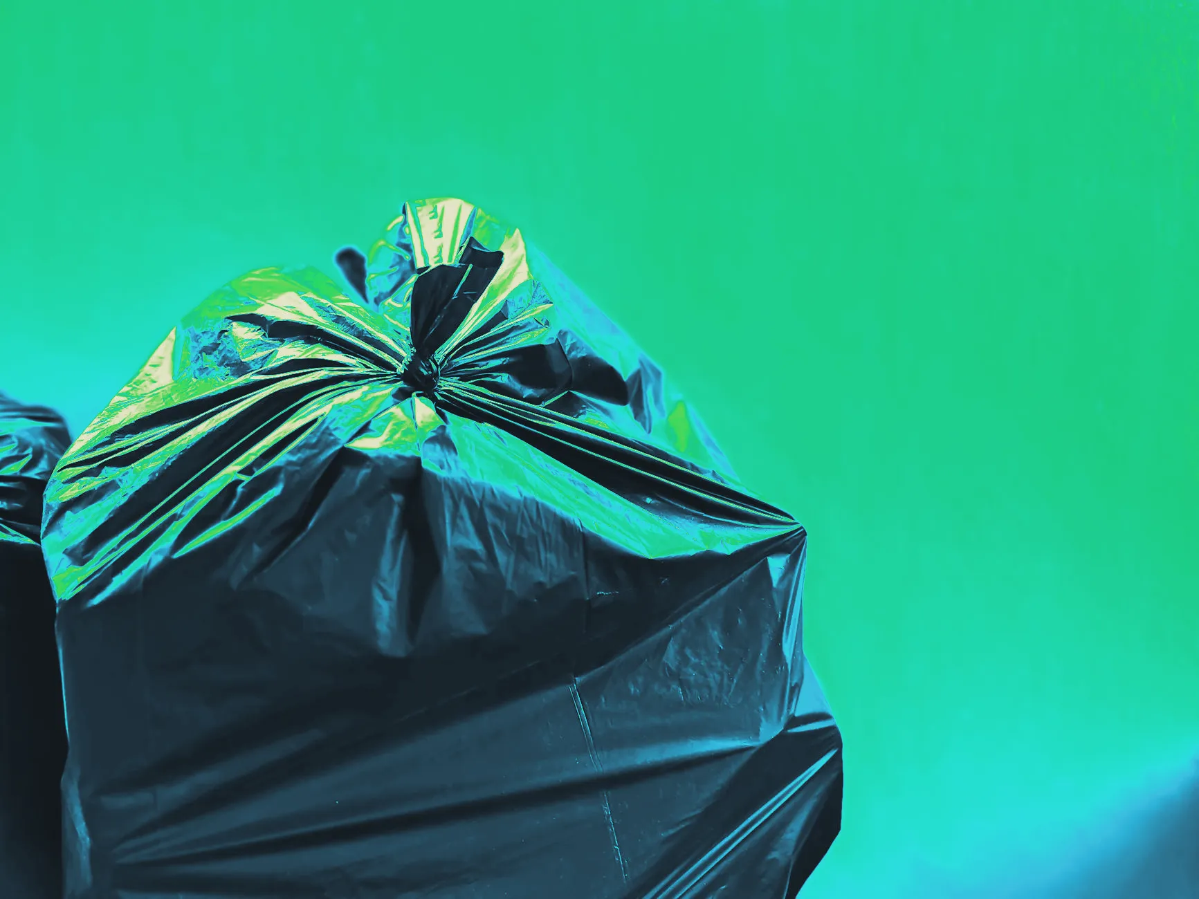 A kitchen trash bag being tied closed, close up